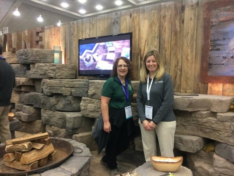 Jodi Tyler with sales rep standing in front of awesome wall block by New Line Hardscapes