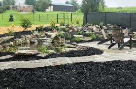 Aquascape Ecosystem Pond built by Certified Aquascape Contractor and Pond Builder Kingdom Landscaping in Sabillasville Maryland featuring a wetland filtration system soaking pond stream koi pond and skimmer system with flagstone patio